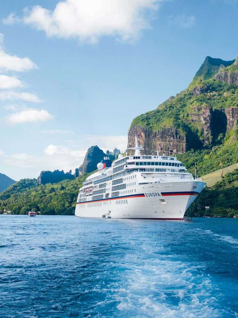 MS Europa von Hapag Lloyd Kreuzfahrten in einer atemberaubenden Bucht von Moorea umgeben von grünen Bergen